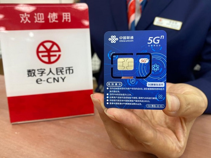 中国联通西单营业厅的一名工作人员正在展示可以支持数字人民币在无网无电环境下支付的超级SIM卡。新华社记者吴雨